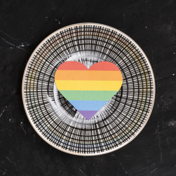 Rainbow lgbt heart on round plate on black background Free Photo