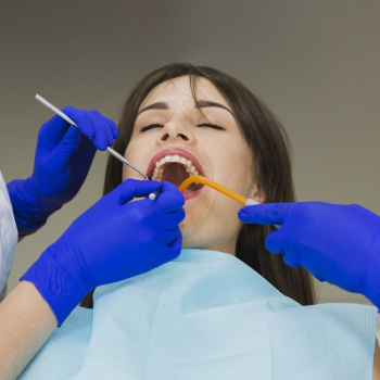 Woman getting her teeth checked by dentists Free Photo