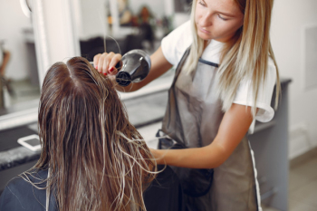 Woman drying hair in a hairsalon Free Photo