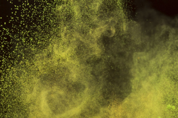 Bright yellow powder in motion Free Photo