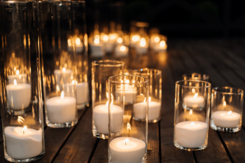 Burning candles in the transparent glass candlestick on the floor Free Photo