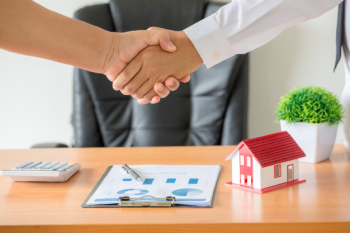 Hands of agent and client shaking hands after signed contract buy new apartment. Free Photo
