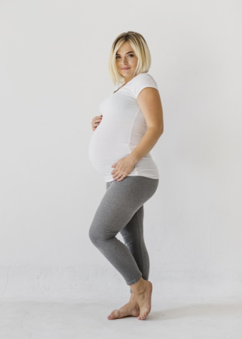 Pregnant woman posing while looking at camera Free Photo