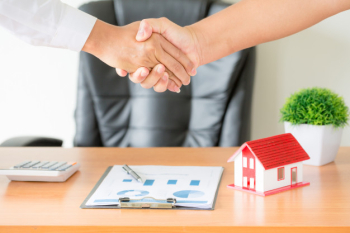 Hands of agent and client shaking hands after signed contract buy new apartment. Free Photo