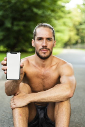 Medium shot of man holding phone mock-up Free Photo
