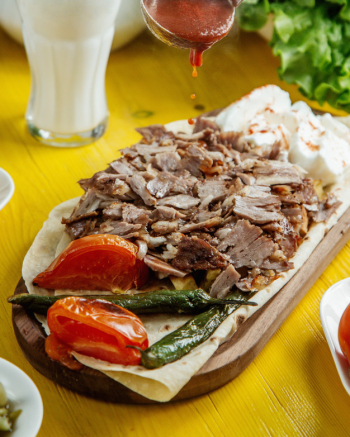 Side view of beef doner kebab on the plate with grilled vegetables Free Photo