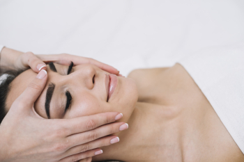 Woman receiving a relaxing facial massage Free Photo