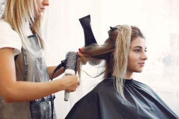 Woman drying hair in a hairsalon Free Photo