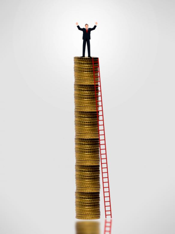 Businessman on top of gold coin stack