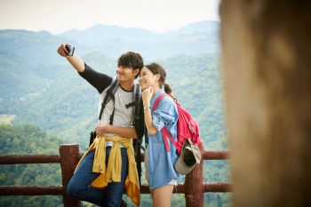 a beautiful couple is taking selfie with modern smartphone on the balcony