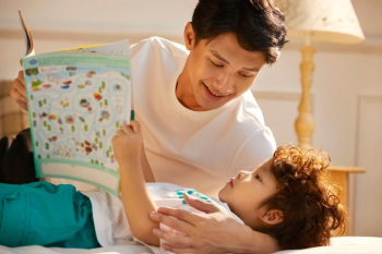 A cute boy is listening intently to a fairy tale his father's telling before sleeping  
