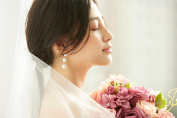 A young beautiful bride is posing in wedding dress and flower bouquet