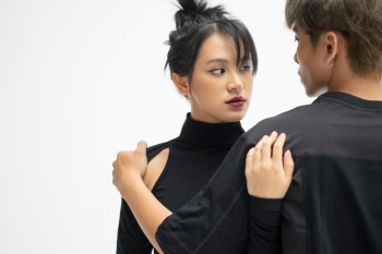 A young couple in black clothes is posing in a cool way
