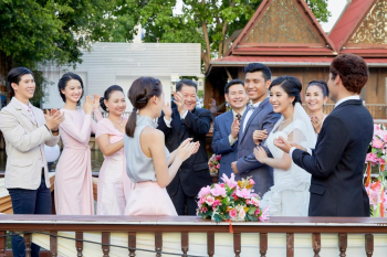guests are clapping for happy newlyweds outdoors