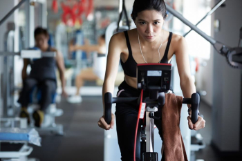 A woman is riding with auto bike at fitness center
