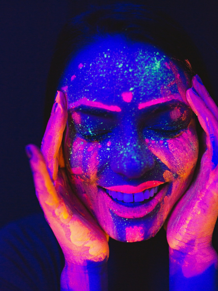 art,artistic,beautiful,close-up,colorful,creative,dark,design,face,face paint,facial expression,female,festival,fluorescent,fun,halloween,hands,illuminated,light,makeup,model,neon,painting,person,portrait,pose,style,teeth,ultraviolet,woman