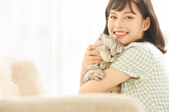 A happy young beautiful woman is playing with her cat - Nohat - Free for designer